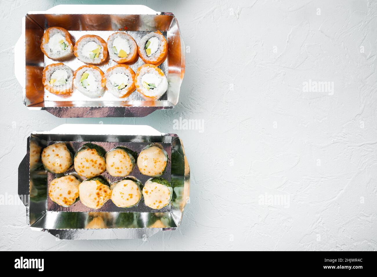 Japanisches Speisekonzept. Catering, verschiedene Arten von Sushi philadelphia Brötchen und gebackene Garnelenrollen Set, auf weißem Stein Hintergrund, Draufsicht Flat Lay, w Stockfoto