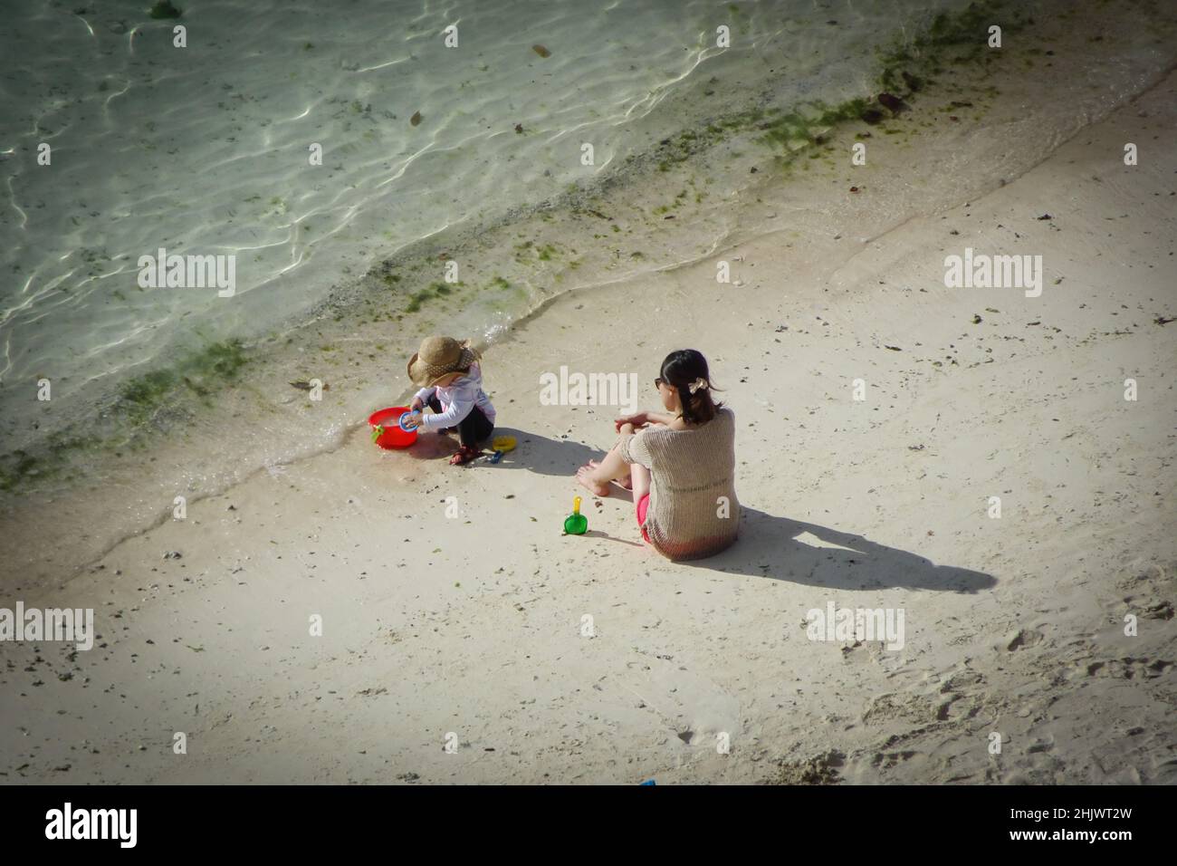 Luftaufnahme von zwei Kindern, die am Strand der Tumon Bay in Guam in der Nähe des Wassers spielen Stockfoto