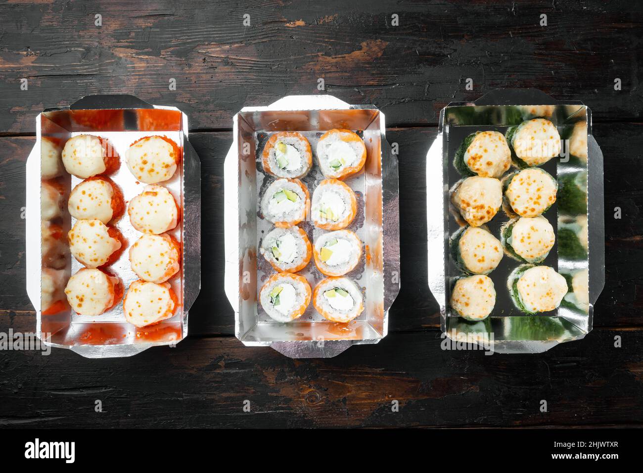 Sushi Roll Delivery Set, auf altem dunklen Holztischhintergrund, Draufsicht flach liegend, mit Copyspace und Platz für Text Stockfoto