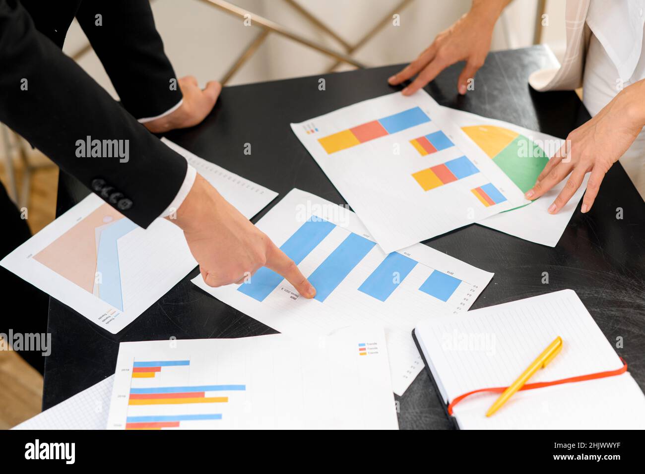 Beschnittene Ansicht des Mannes und der Frau, die Dokumente diskutieren, während sie am Tisch stehen und mit den Fingern zeigen. Stock Foto Stockfoto