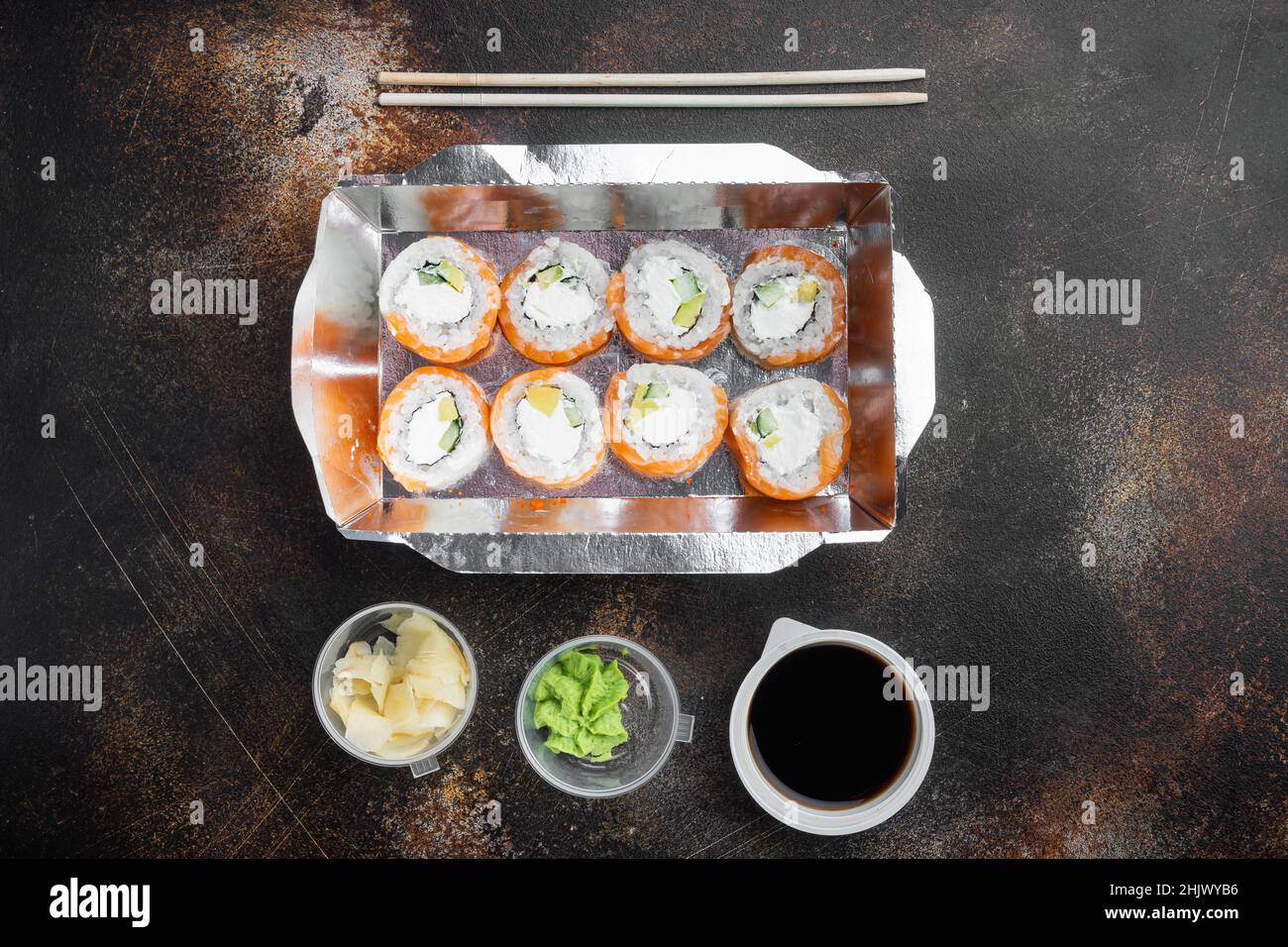 Sushi Roll Delivery Set, auf altem dunklen rustikalen Hintergrund, Draufsicht flach liegend, mit Copyspace und Platz für Text Stockfoto