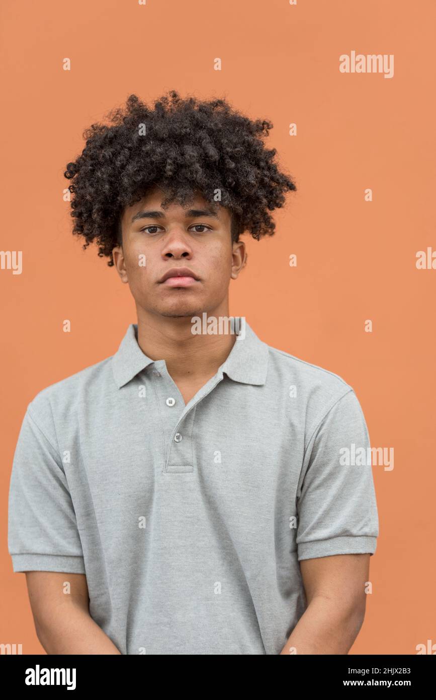 Porträt eines ernsten afroamerikanischen Mannes, der die Kamera anschaut, isoliert auf lachsfarbenem Hintergrund, Panama, Mittelamerika Stockfoto