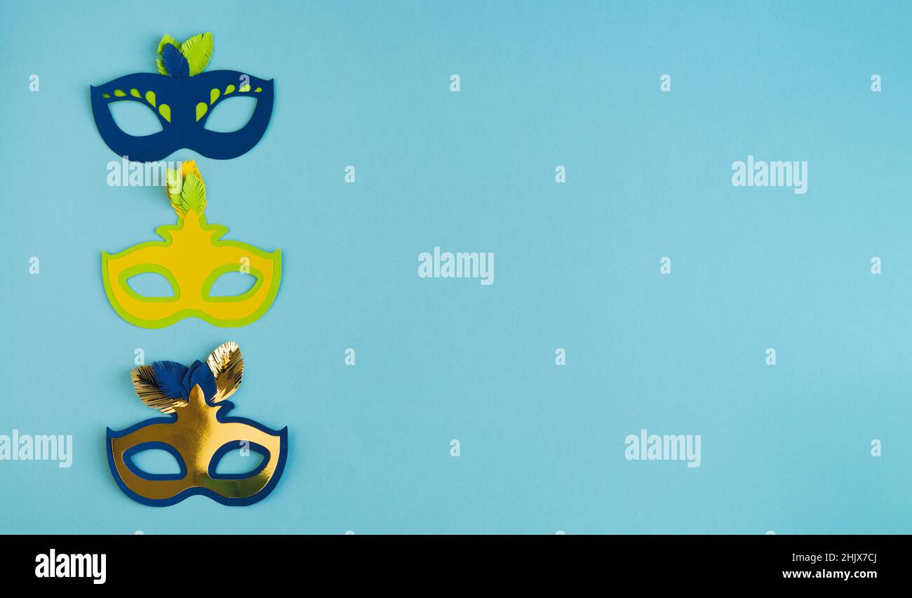 Drei Karnevalsmasken vertikal auf blauem Hintergrund. Speicherplatz kopieren. Stockfoto