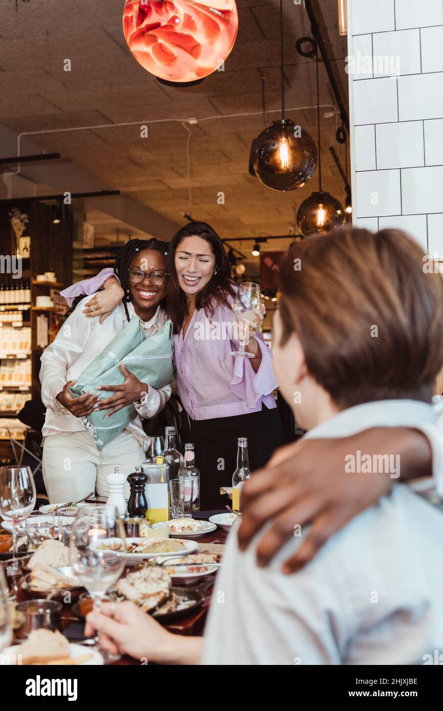 Glückliche weibliche und männliche Freunde feiern während der Party in der Bar Stockfoto