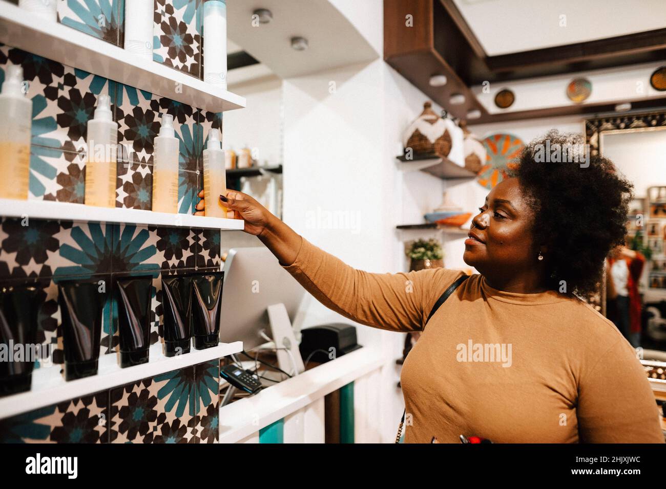 Reife weibliche Kundin, die im Friseursalon Beauty-Produkte kauft Stockfoto
