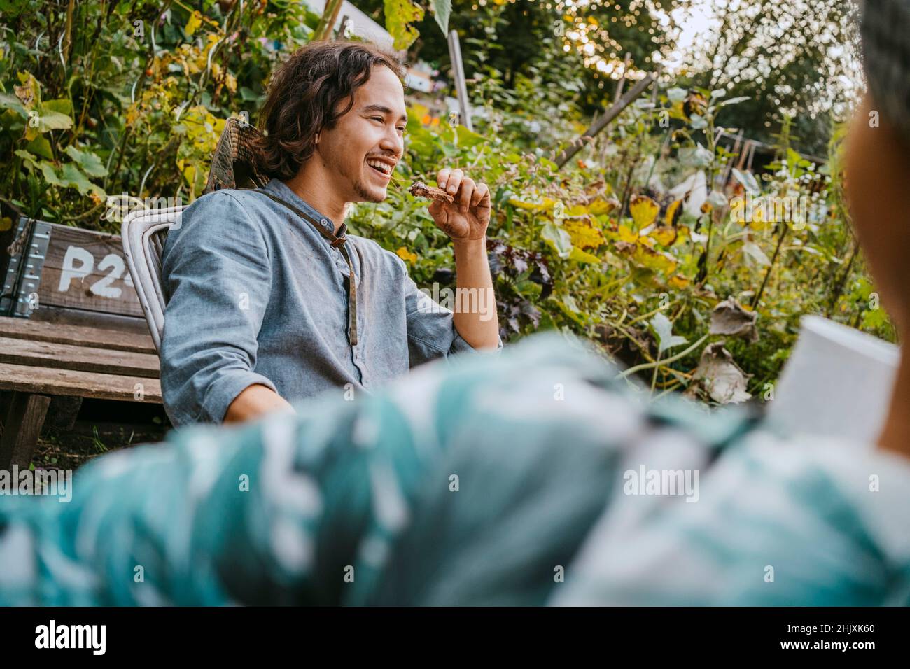 Glücklicher Mann, der mit einer Freiwilligen-Frau im Garten Essen hat Stockfoto