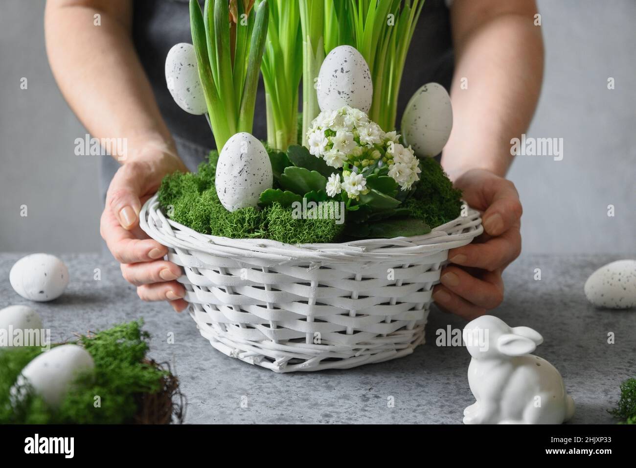 DIY Ostertisch Herzstück mit festlichen Eiern, frischem Sprossen Narzisse, Moos und Hase. Frühlingskomposition. Blumenwerkstatt. Nahaufnahme. Stockfoto