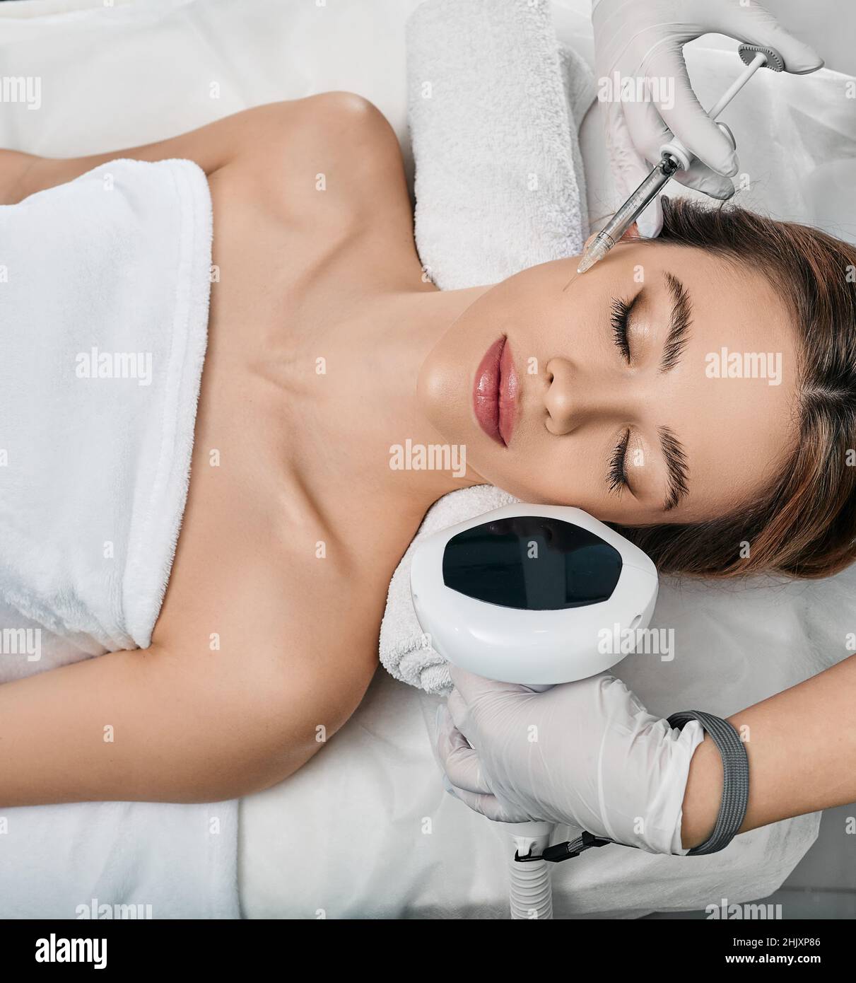 Kosmetische Gesichtspflege. Kosmetologe illustriert Gesichtsbehandlungen wie Schönheitsinjektionen und Fotorejuvenation Lumecca IPL Stockfoto