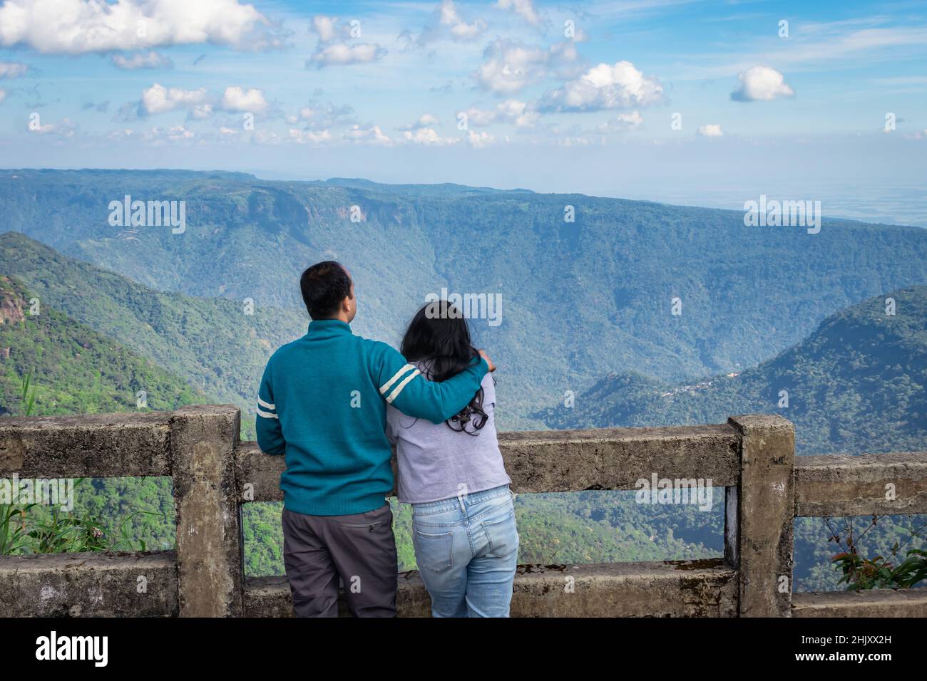 Das junge Paar, das am Nachmittag die Bergkette mit hellblauem Himmel aus einem flachen Winkel beobachtet, wurde am sieben Schwester-Wasserfall cherrapunji meghal aufgenommen Stockfoto