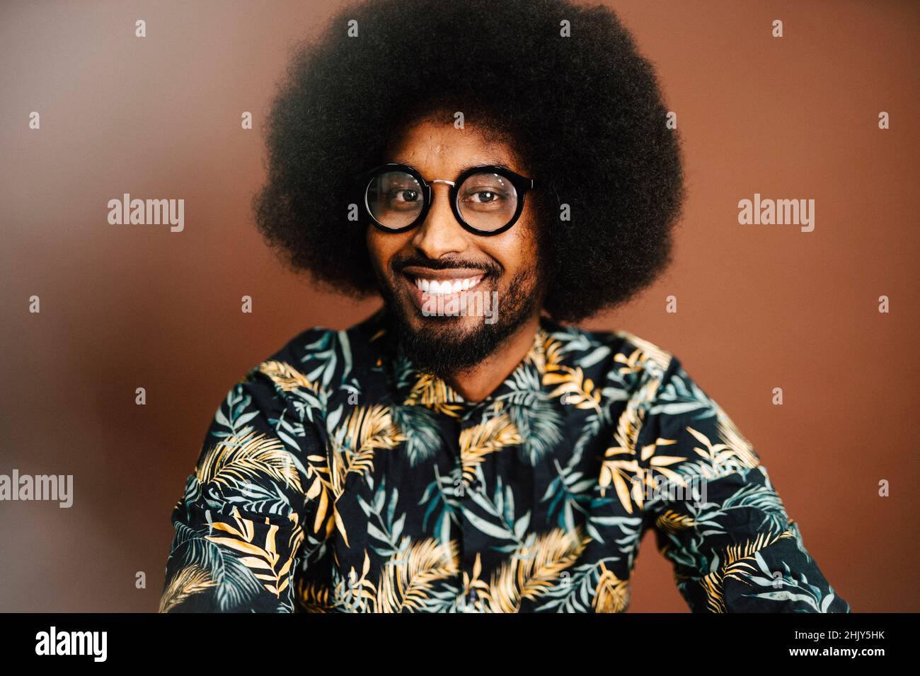 Porträt eines lächelnden Mannes mit Afro-Frisur im Studio Stockfoto