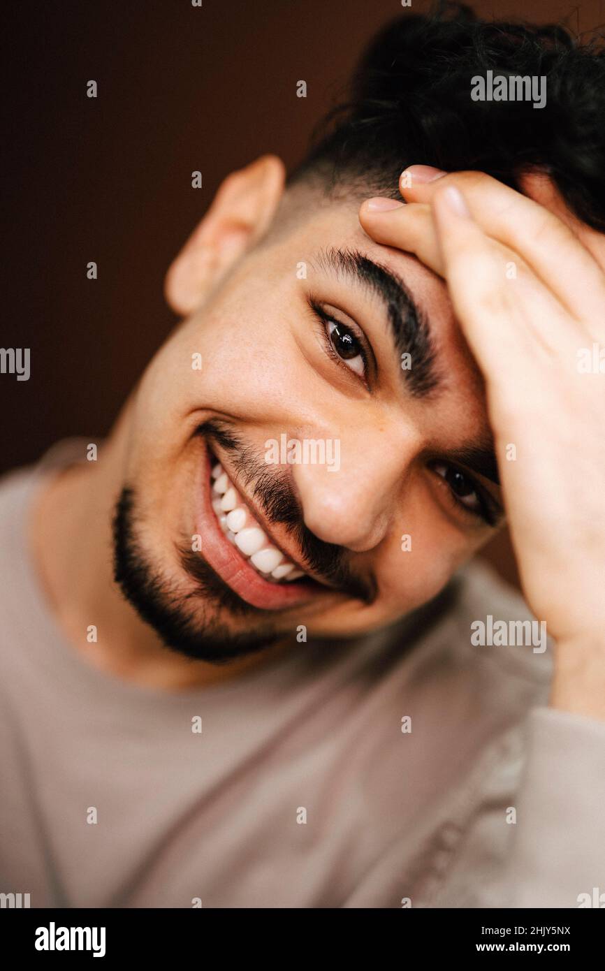 Porträt eines lächelnden Mannes mit Kopf in der Hand im Studio Stockfoto
