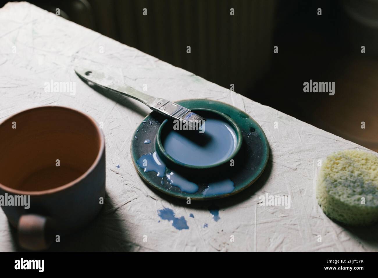 Hohe Winkelansicht von Farbe und Pinsel am Tisch Stockfoto