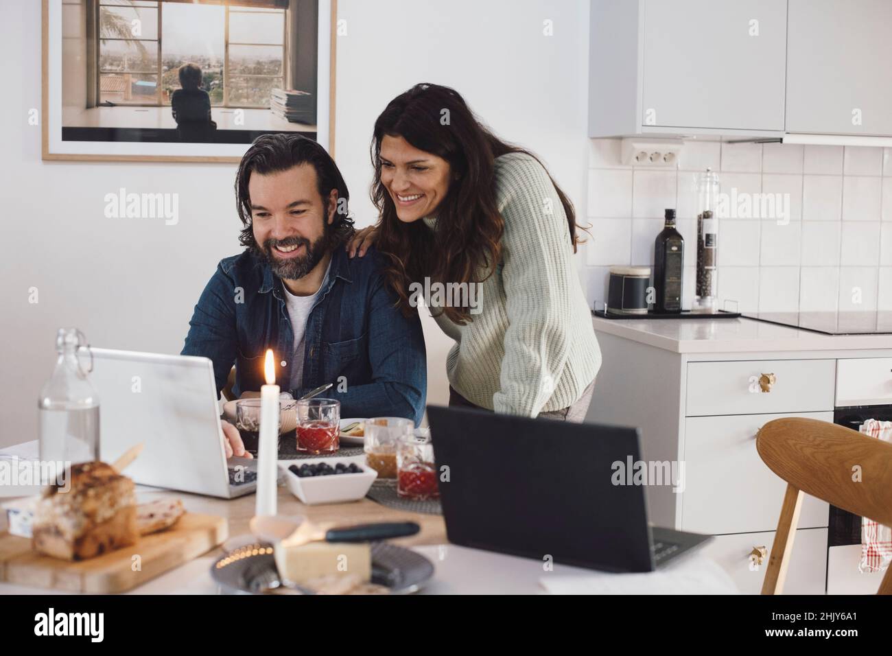 Lächelnde älteres Paar mit Laptop zu Hause Stockfoto