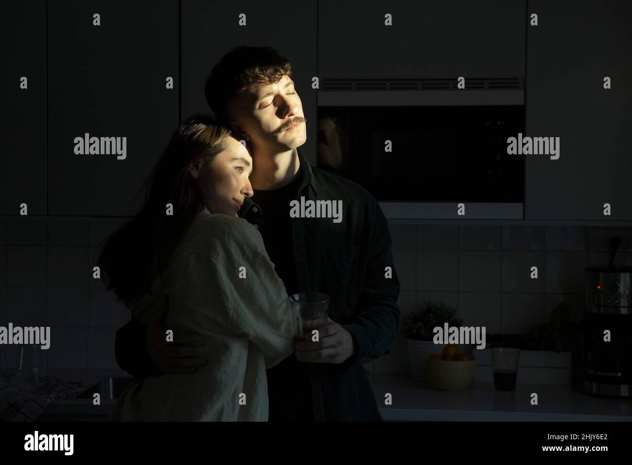 Freundin umarmt Freund stehen in der Küche Stockfoto
