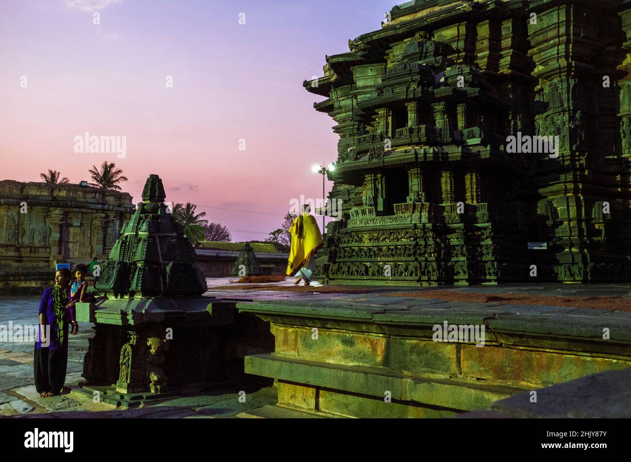 Belur, Karnataka, Indien : Chennakeshava-Tempel aus dem 12. Jahrhundert. Ein Hindu-Priester geht bei Sonnenuntergang auf der Jagati-Plattform zur Umgehung (pradakshina-p Stockfoto