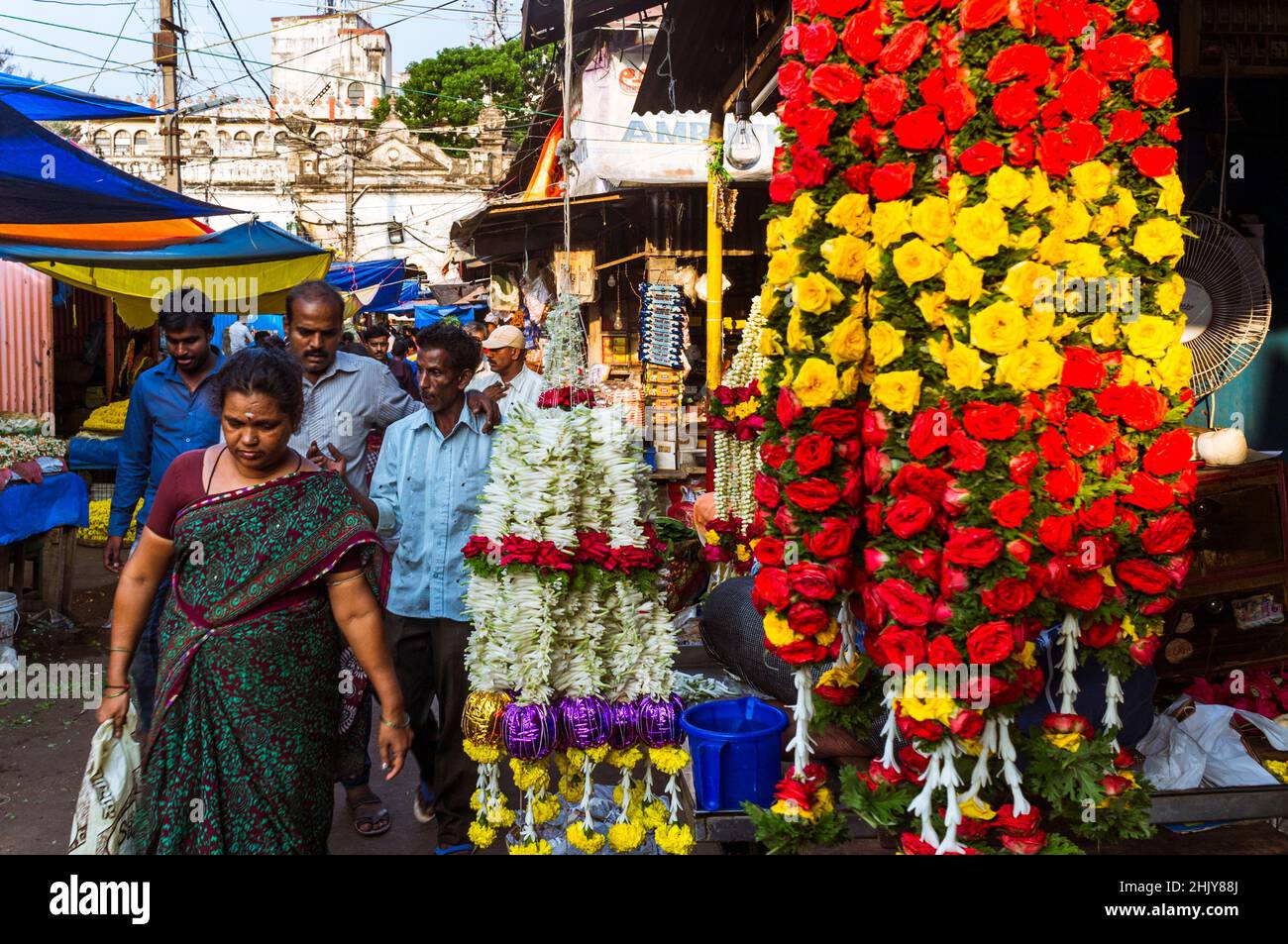 Mysore, Karnataka, Indien : Eine Frau geht am Devaraja-Markt vorbei an Blumengirlanden. Stockfoto