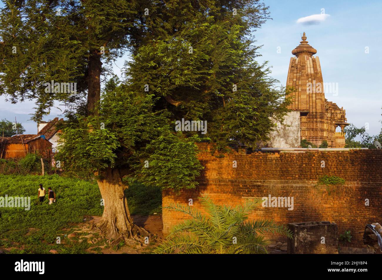 Khajuraho, Madhya Pradesh, Indien : Dorfbewohner wandern auf dem Land um den Vamana-Tempel, der Teil der östlichen Gruppe des UNESCO-Weltkulturerbes S ist Stockfoto