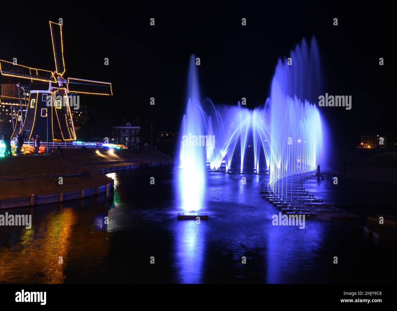 Wasserbrunnen und eine Windmühle in der Nacht Stockfoto