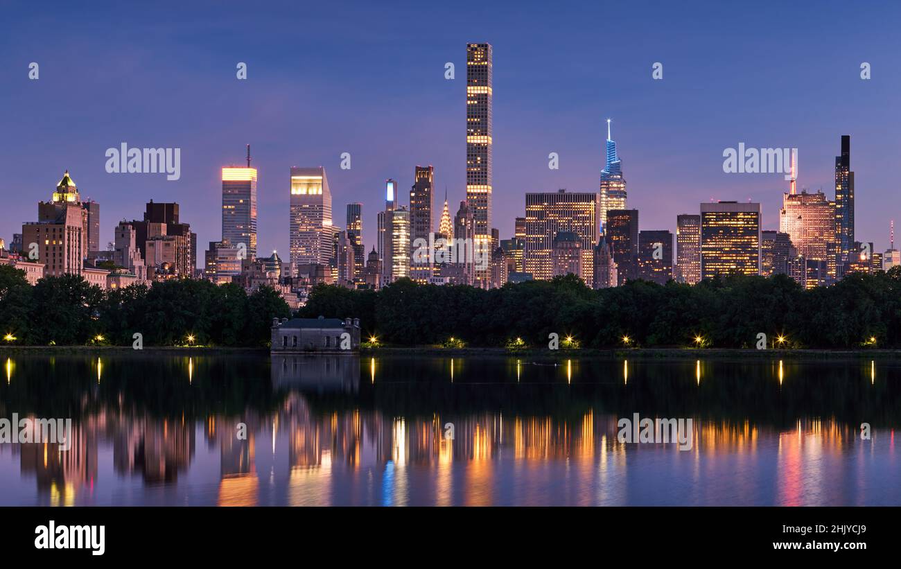 Skyline von New York City. Midtown Manhattan Wolkenkratzer vom Central Park Reservoir at Dusk. Abendansicht der beleuchteten Luxus-Wolkenkratzer Stockfoto