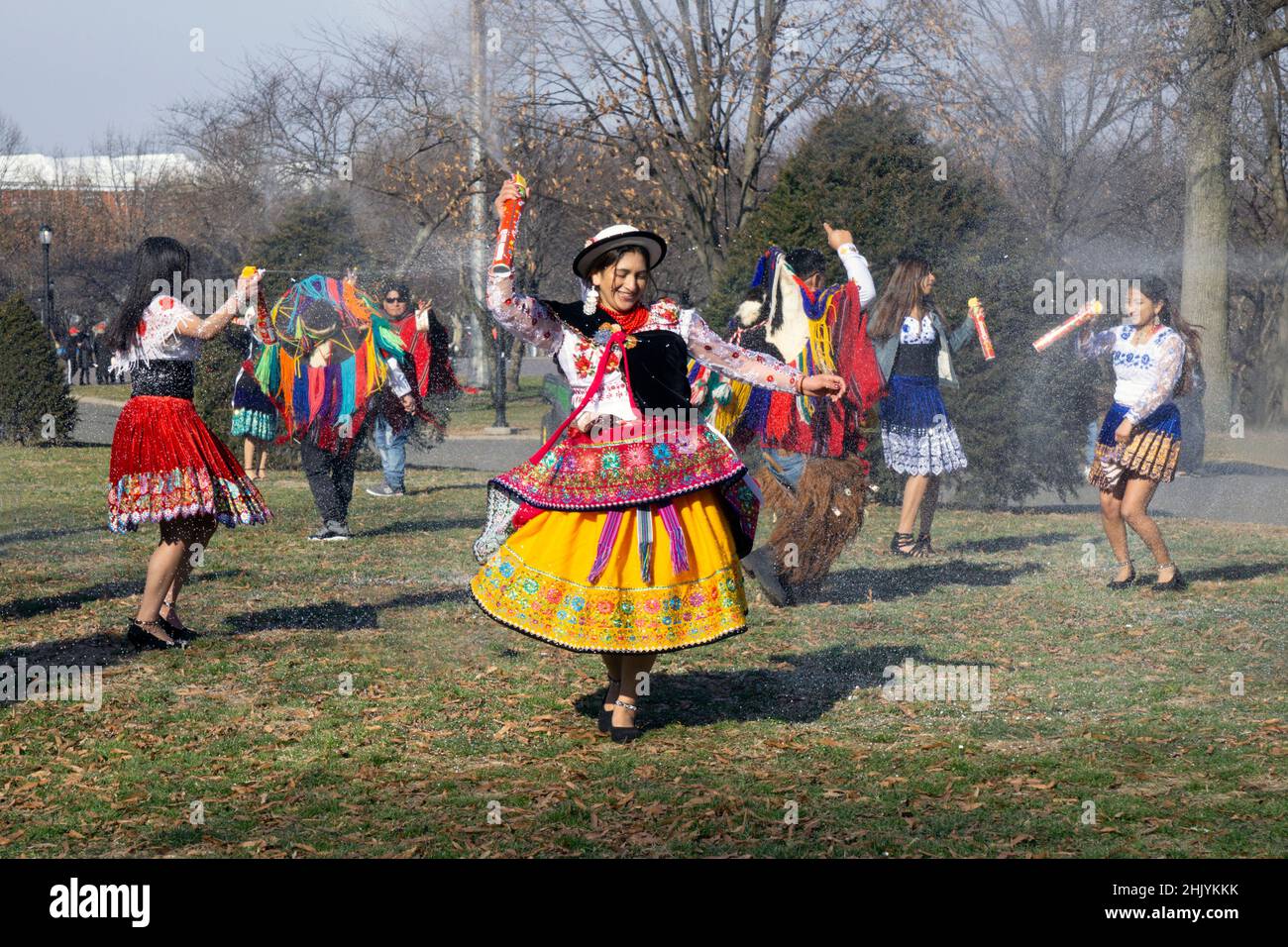 Männer und Frauen aus Ecuador tanzen und spielen Musik, während sie Carioca sprühen, ein Rasiercreme-Spray, das bei Feiern verwendet wird. In Queens, New York. Stockfoto