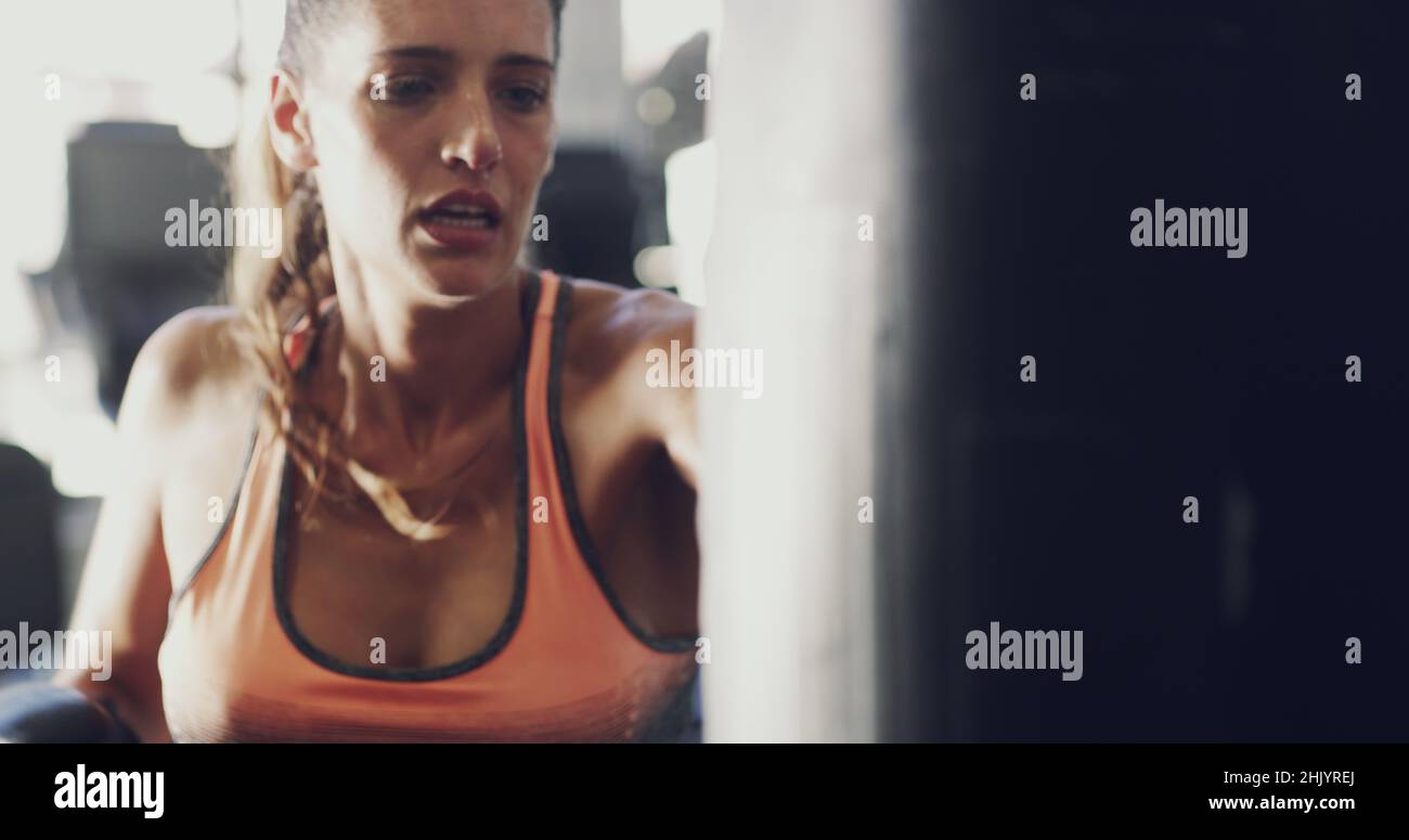 Boxen fordert Ihren Körper heraus. 4K Aufnahmen einer Frau, die im Fitnessstudio an ihrer Boxroutine arbeitet. Stockfoto