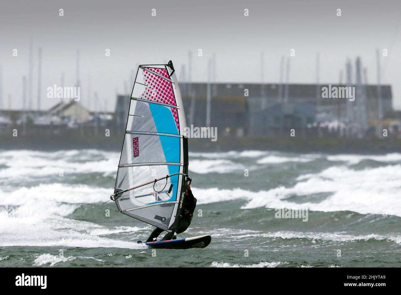 Troon, Großbritannien. 01st. Februar 2022. Am Ende von Storm Corrie, wenn der Wind auf 45 km/h abfällt, fahren Windsurfer zum Meer am North Beach, Troon, Ayrshire, um ihren Sport im Schutz des Hafens von Troon zu genießen. Kredit: Findlay/Alamy Live Nachrichten Stockfoto