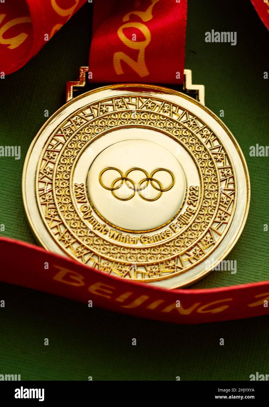 27. Januar 2022, Peking, China. XXIV. Olympische Winterspiele Goldmedaille auf grünem Hintergrund. Stockfoto