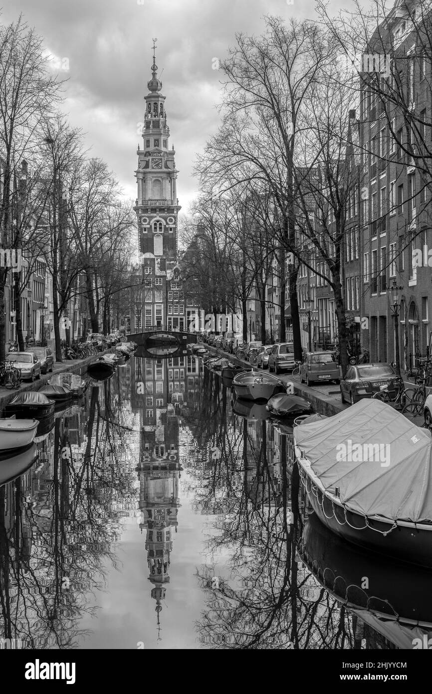 Schwarz-weiße Hillsong Kirche mit mehreren geparkten Fahrrädern und Booten auf einem Amsterdamer Kanal Holland Stockfoto