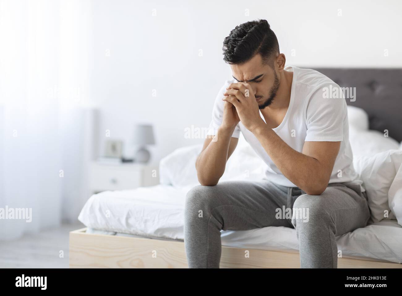 Porträt Eines Deprimierten Jungen Arabischen Guys, Der Zu Hause Auf Dem Bett Sitzt Stockfoto