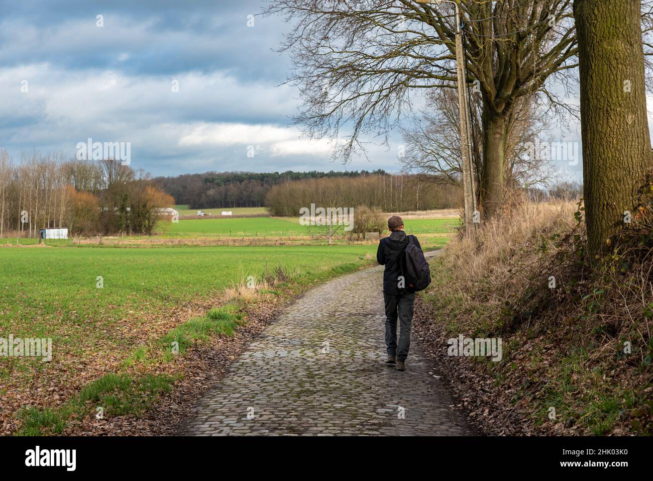 Lovenjoel, Flämische Brabant Region, Belgien - 01 29 2022: Mann auf einer weichen Straße durch die Felder der Landwirtschaft Stockfoto