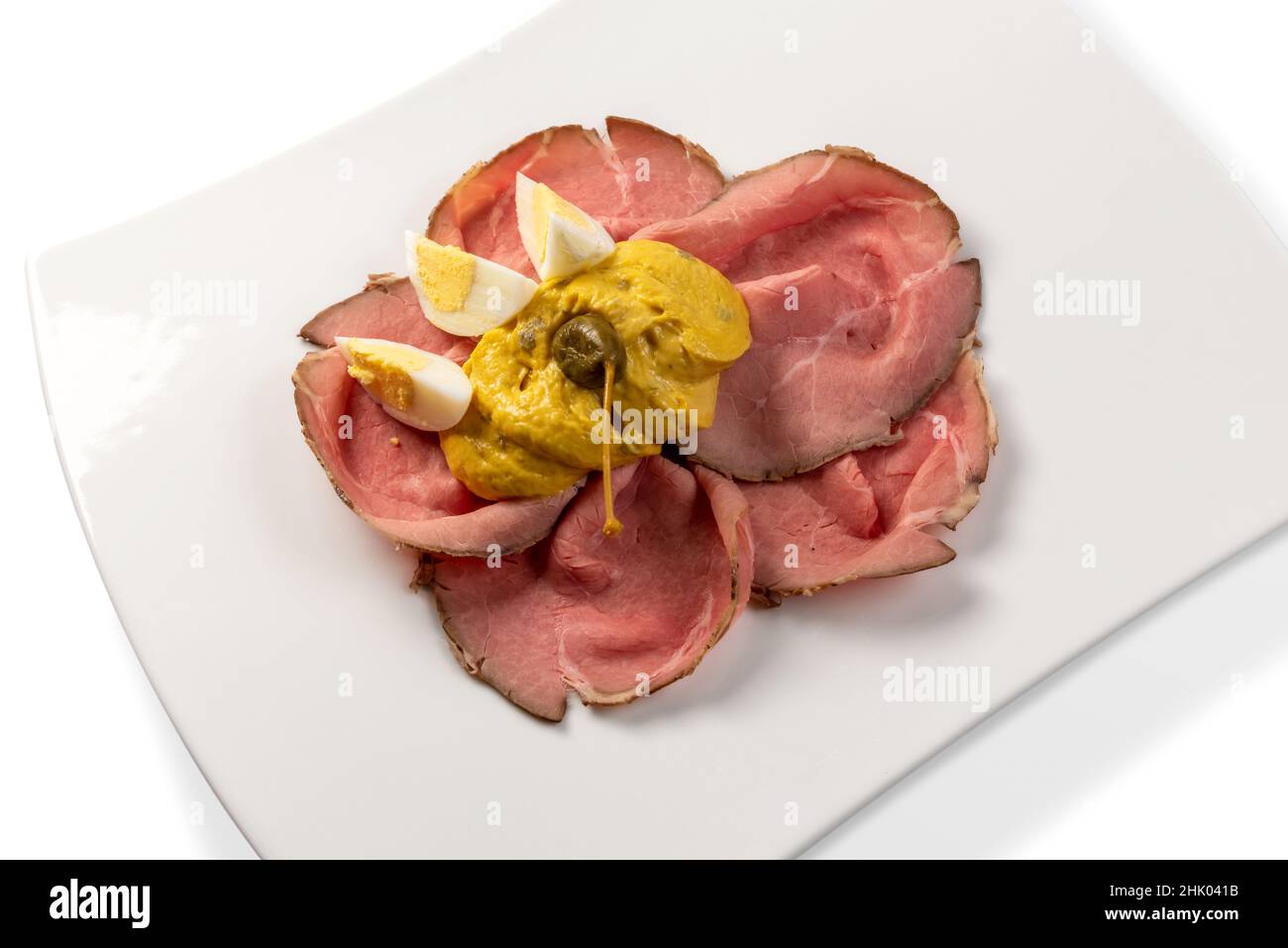 Vitello tonnato, typisch italienisches Roastbeef aus dem Piemont mit Thunfisch-Mayonnaise-Sauce und Kapern, Scheiben in weißer Platte mit gekochten Eierscheiben und Kapern Stockfoto