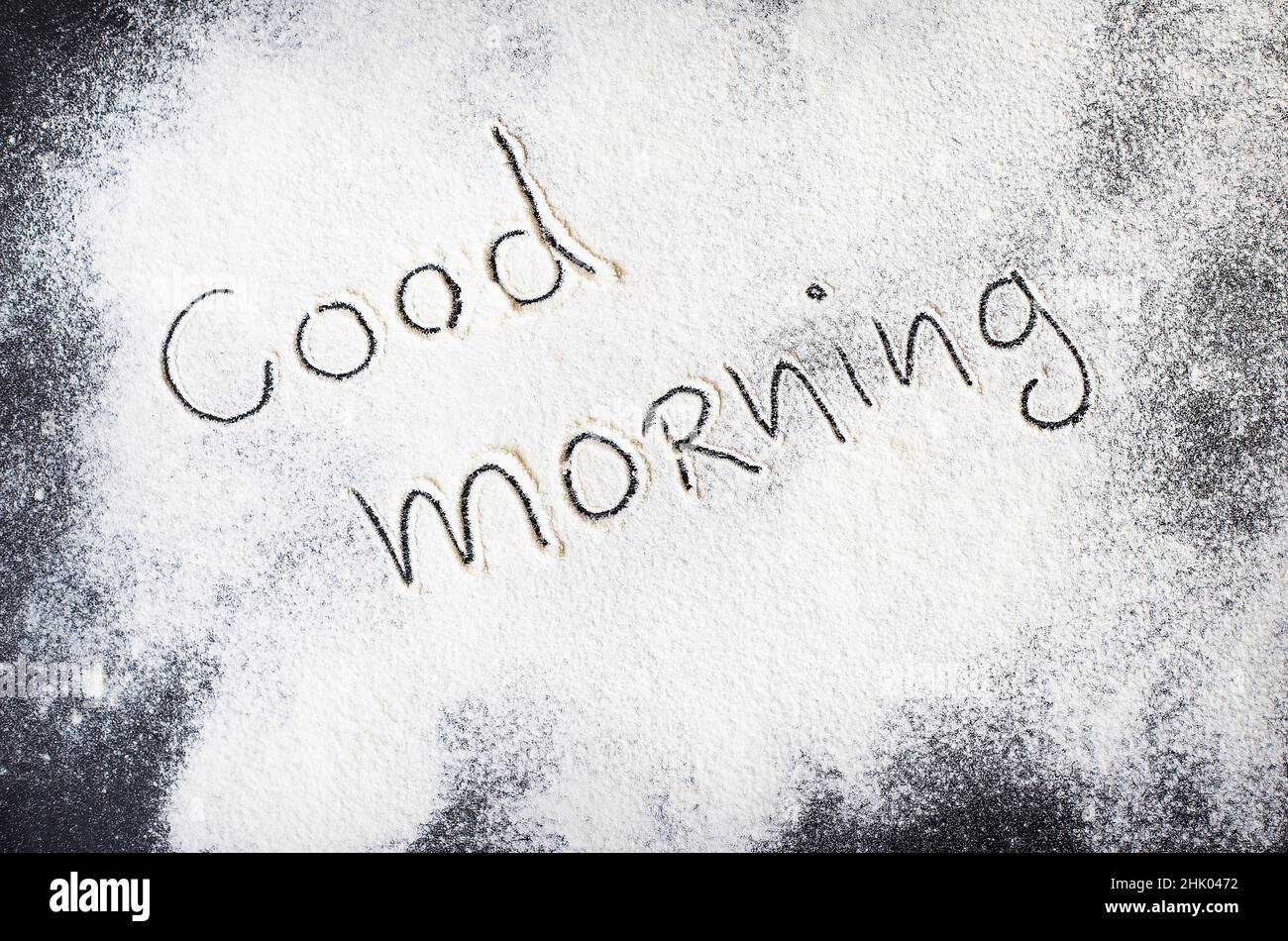 Guten Morgen Beschriftung auf dem Brett mit Mehl. Stockfoto