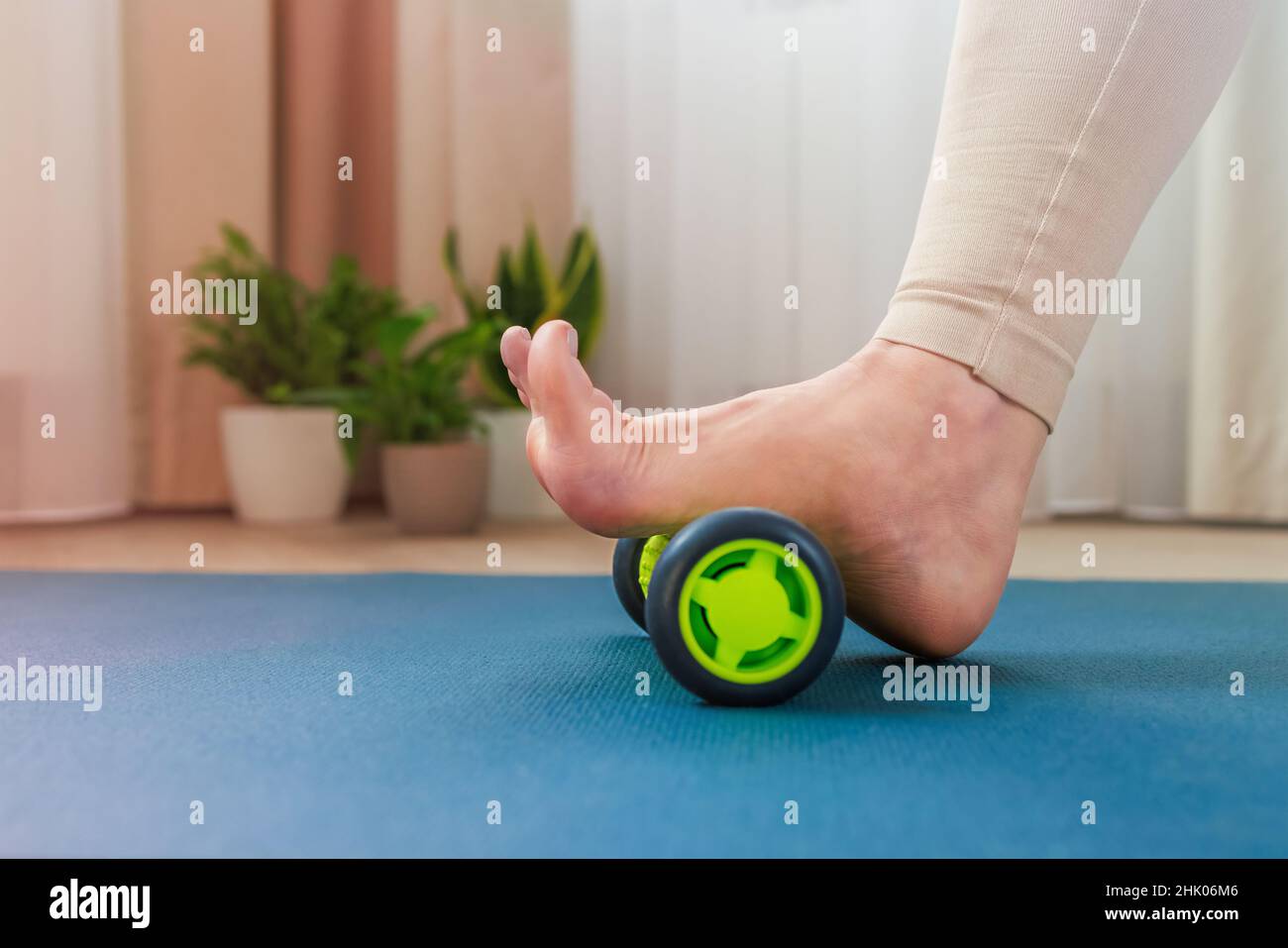 Rollen des oberen Fußbogens mit einer Massagerolle Stockfoto