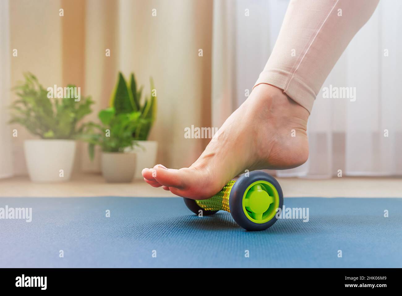 Selbstmassage der Beine selbst zu Hause mit einem Roller-Massagegerät Stockfoto