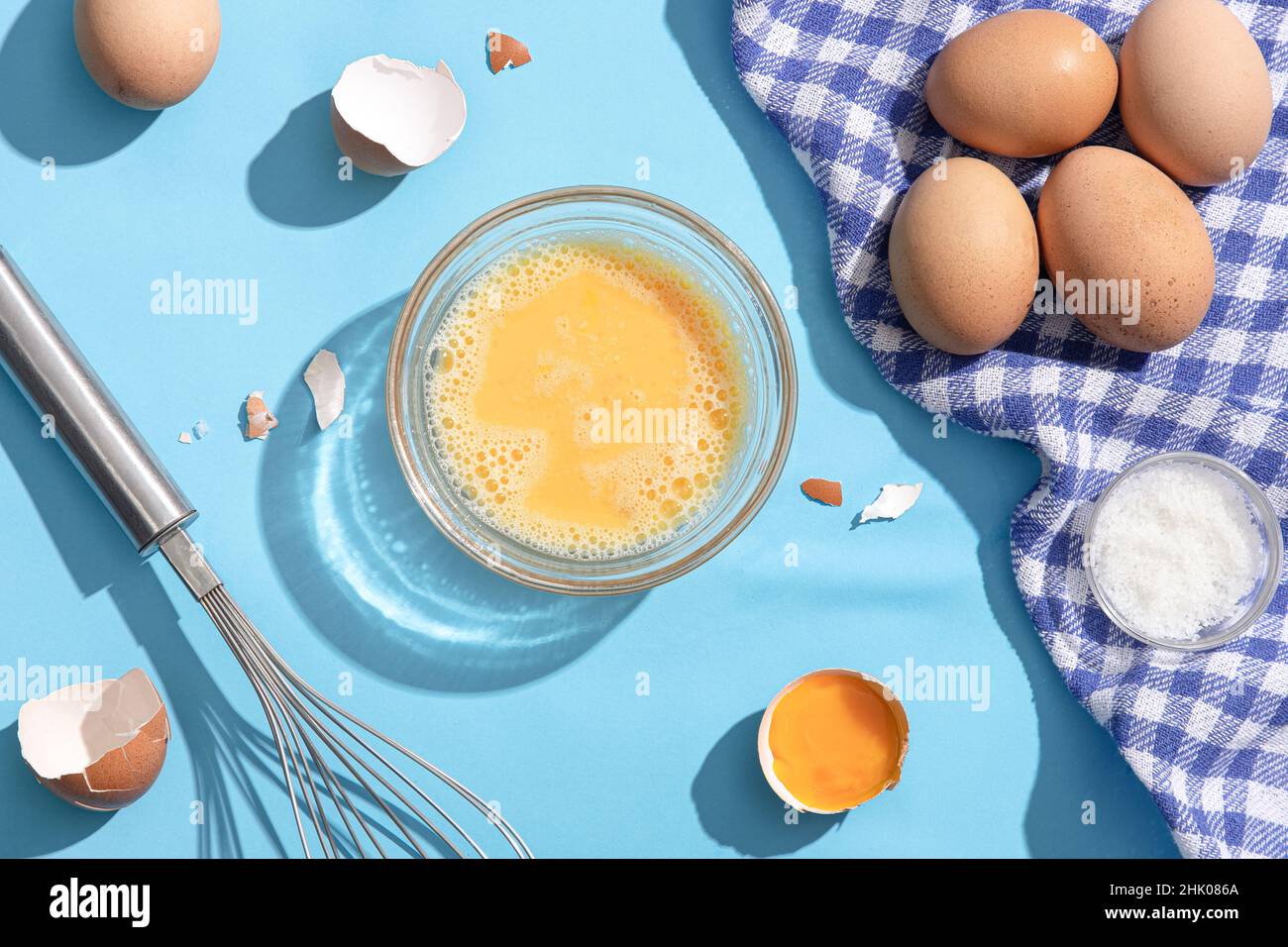 Geschlagene Eier auf blauem Hintergrund. Flach liegend. Stockfoto