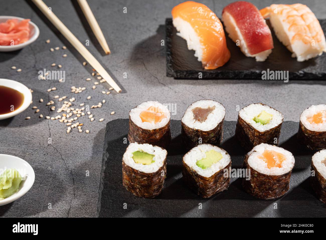 Nahaufnahme einer frischen Sushi-Vielfalt auf dunklem Hintergrund. Stockfoto