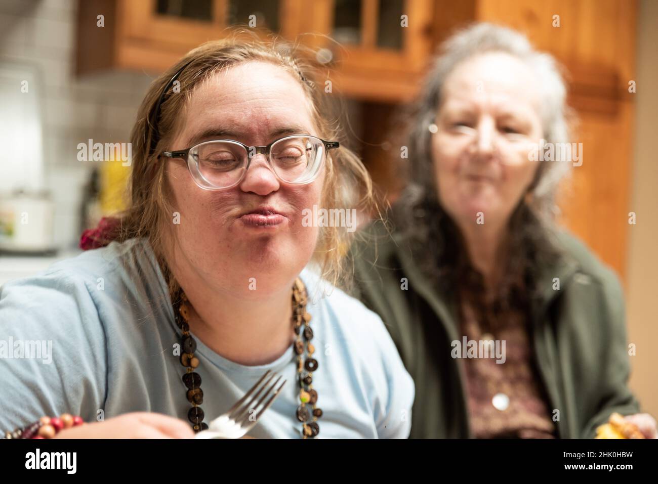 Hachendover, Flämisch-Brabant, Belgien - 09 20 2021: Behinderte 39-jährige Frau und ihre 83-jährige Mutter, die sich zu Hause in der Küche amüsieren. Stockfoto