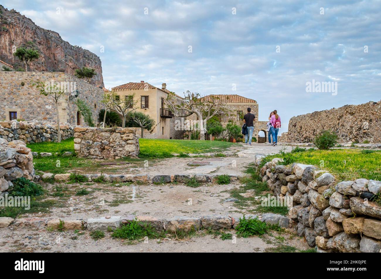 Touristen besuchen die historische Burgstadt auf der Insel Monemvasia, Griechenland. Traditionelle Häuser und mittelalterliche Stadtmauern in einer natürlichen Umgebung Stockfoto