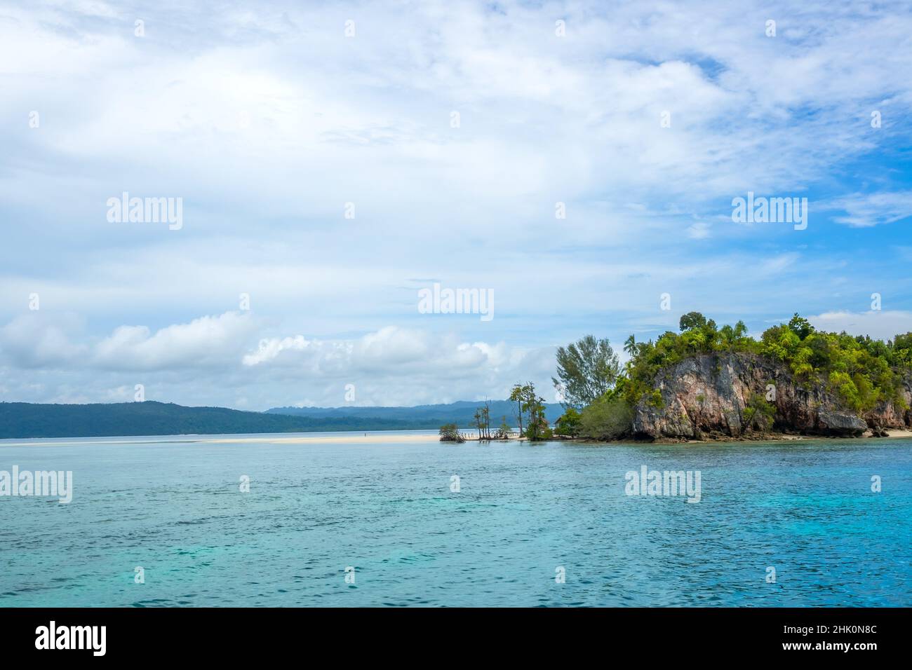Indonesische Insel im Raja Ampat Archipel. Sandspieß an der Küste einer tropischen Insel. Einsame menschliche Figur. Die Hütte versteckt sich hinter dem Stockfoto