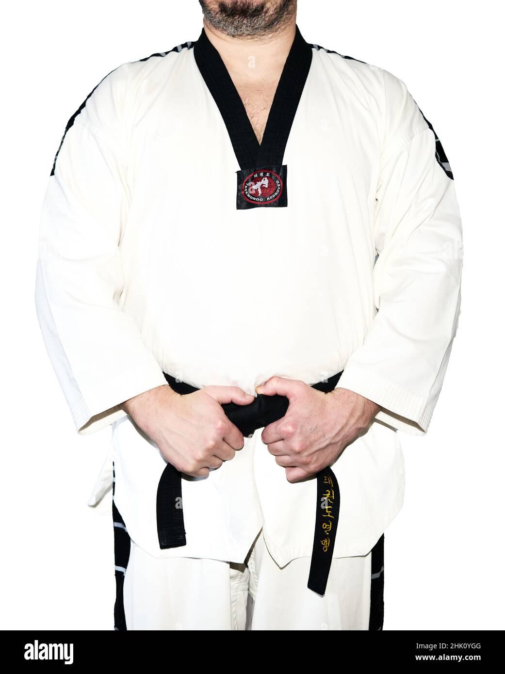 Mann in Taekwondo-Kampfkunstuniform, der seinen schwarzen Gürtel hält, wobei beide Hände auf dem weißen Hintergrund isoliert sind. Stockfoto