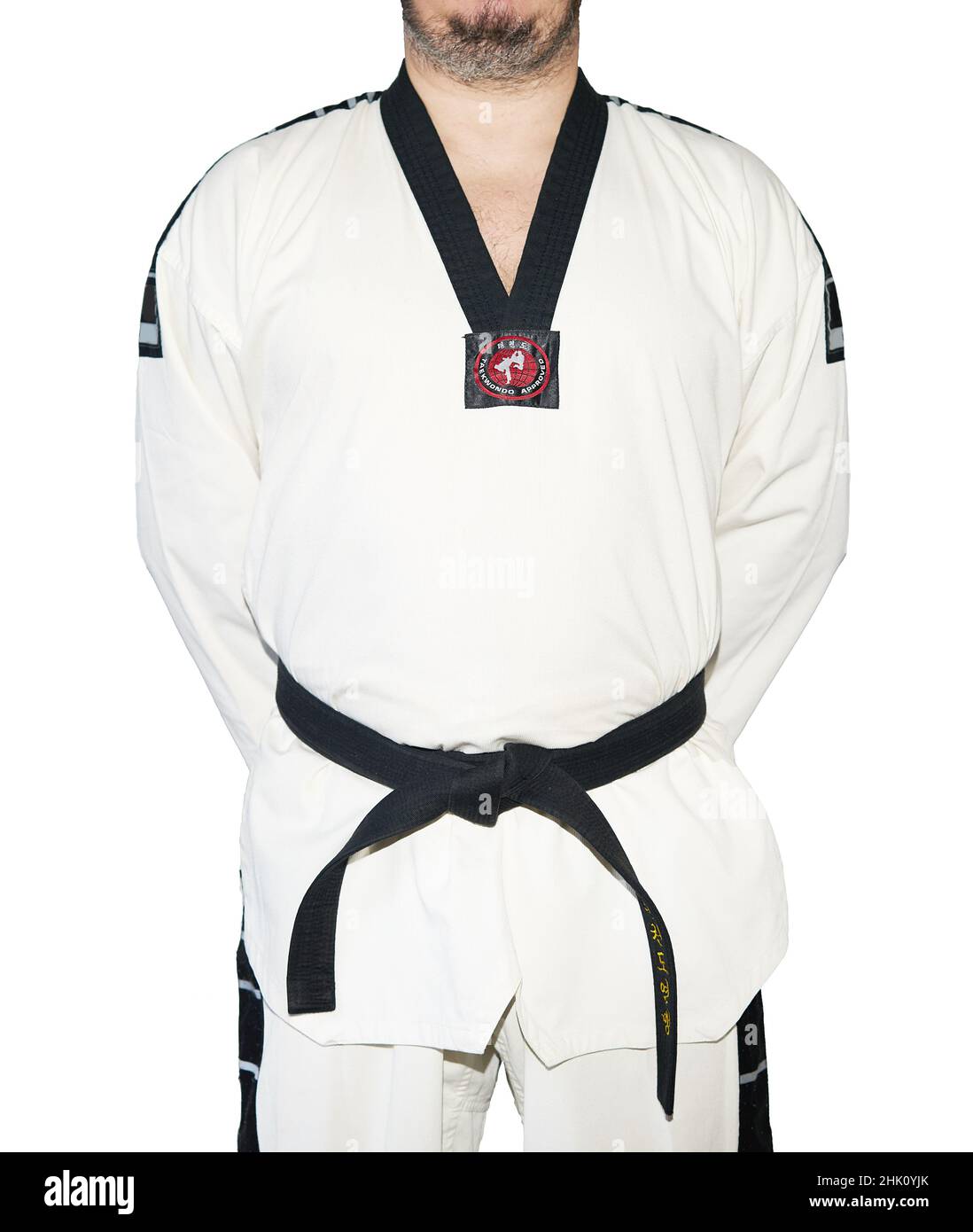 Mann in Taekwondo Kampfkünste Uniform Hände hinter dem Rücken isoliert auf dem weißen Hintergrund. Schwarzer Gürtel Stockfoto