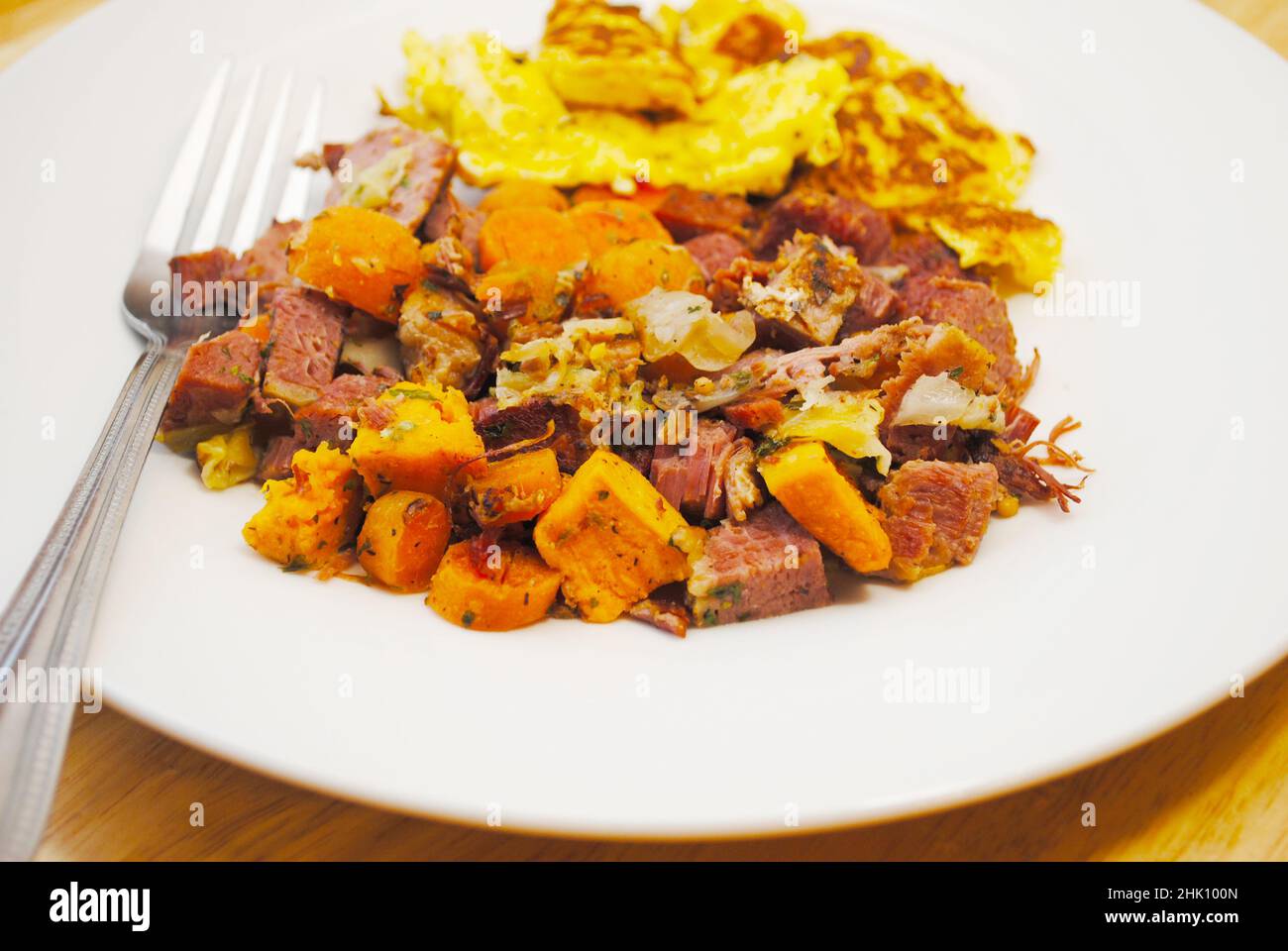 Rinderhasch mit Corned Beef und einer Beilage aus Rühreiern Stockfoto