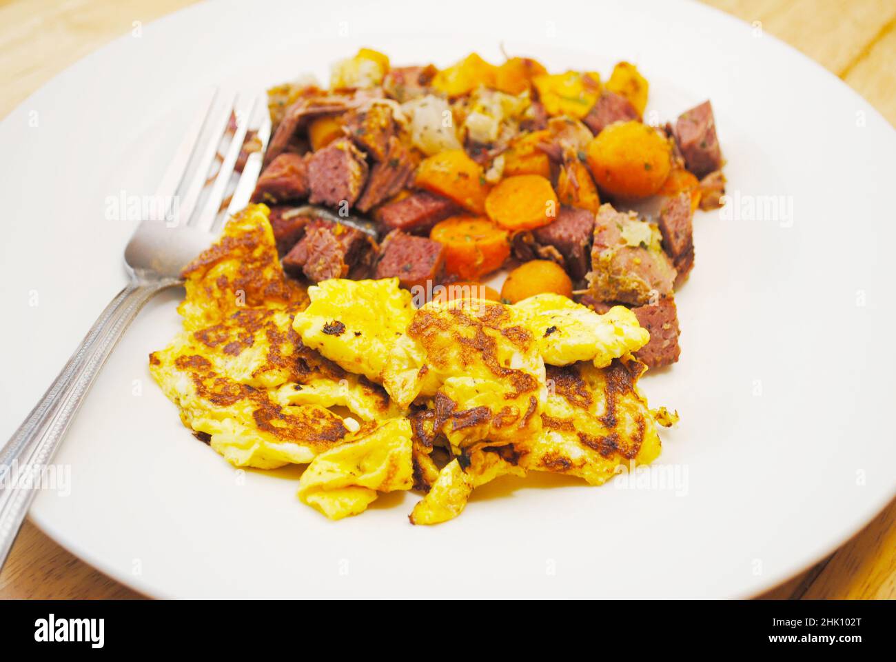 Rinderhasch mit Corned Beef und einer Beilage aus Rühreiern Stockfoto