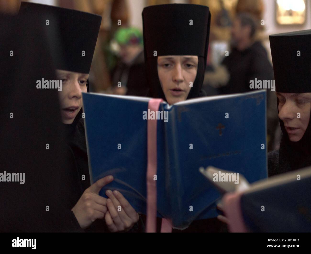 Anzahl der Nonnen, die in einer Kirche in der Ukraine vor einem verschwommenen Hintergrund singen Stockfoto