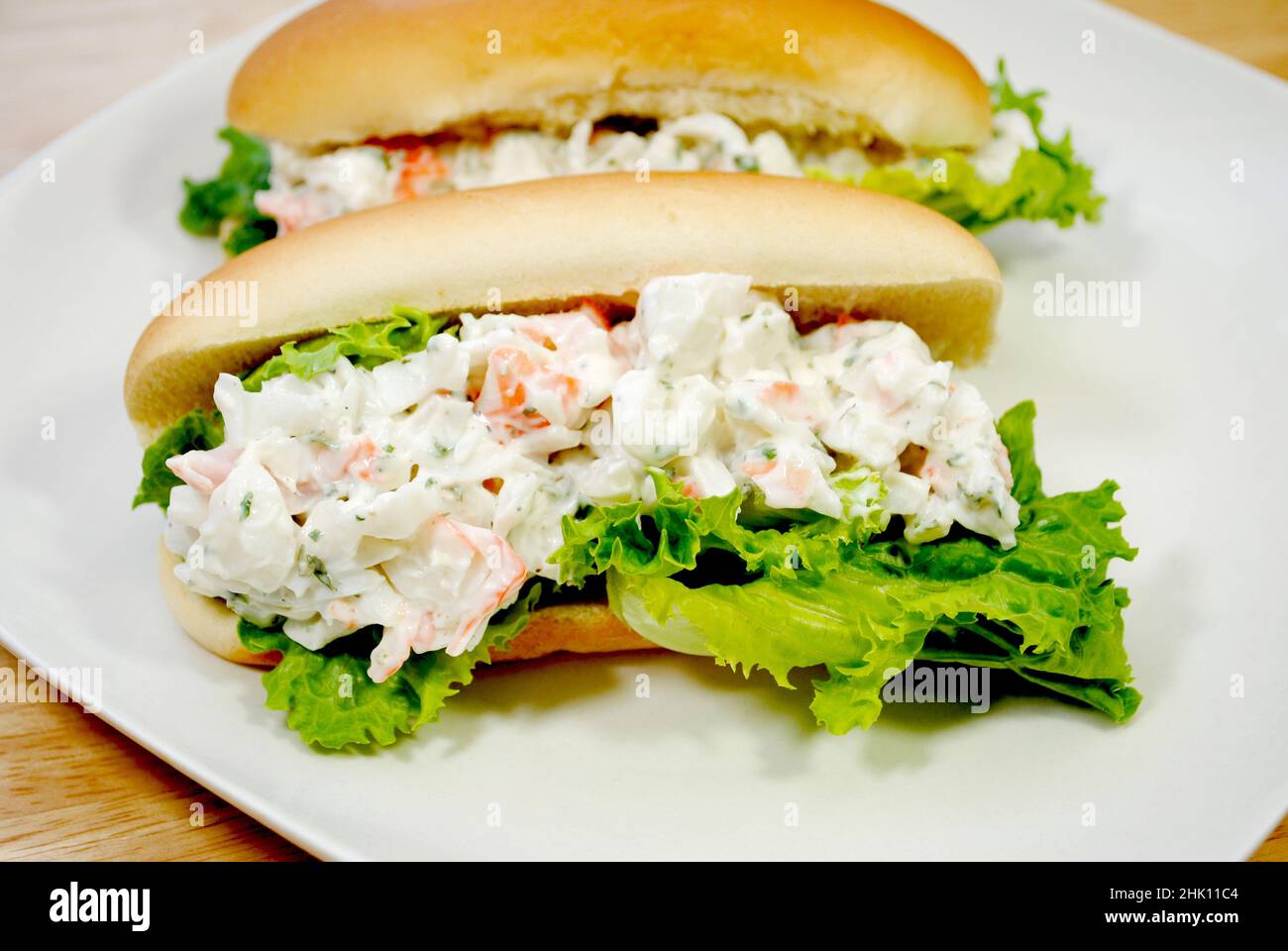 Zwei Meeresfrüchte-Salatsandwiches auf einem weißen Teller Stockfoto