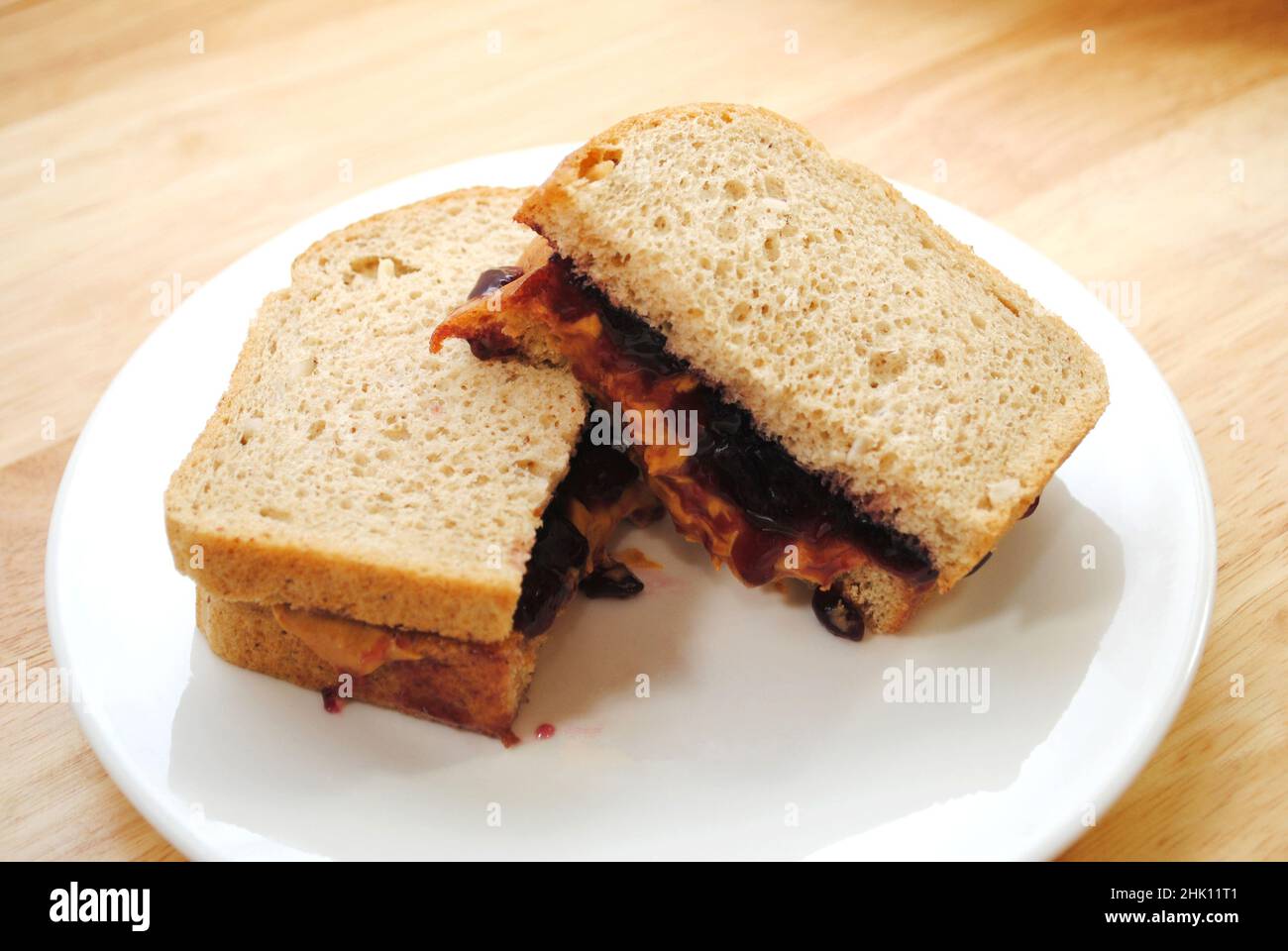 Vorbereiten eines Erdnussbutter- und Gelee-Sandwichs in zwei Hälften geschnitten Stockfoto