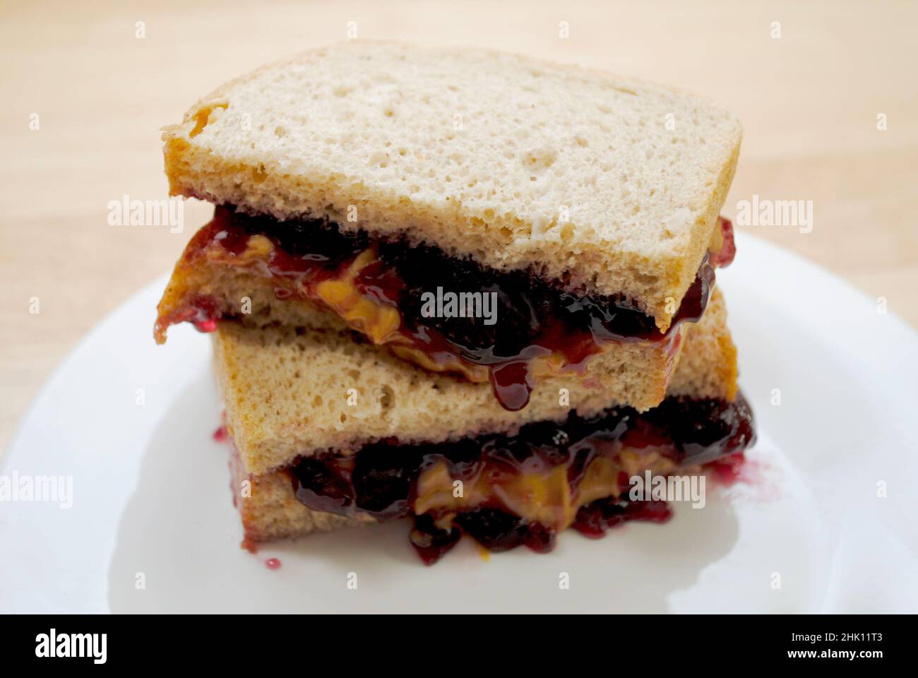 Vorbereiten eines Erdnussbutter- und Gelee-Sandwichs in zwei Hälften geschnitten Stockfoto