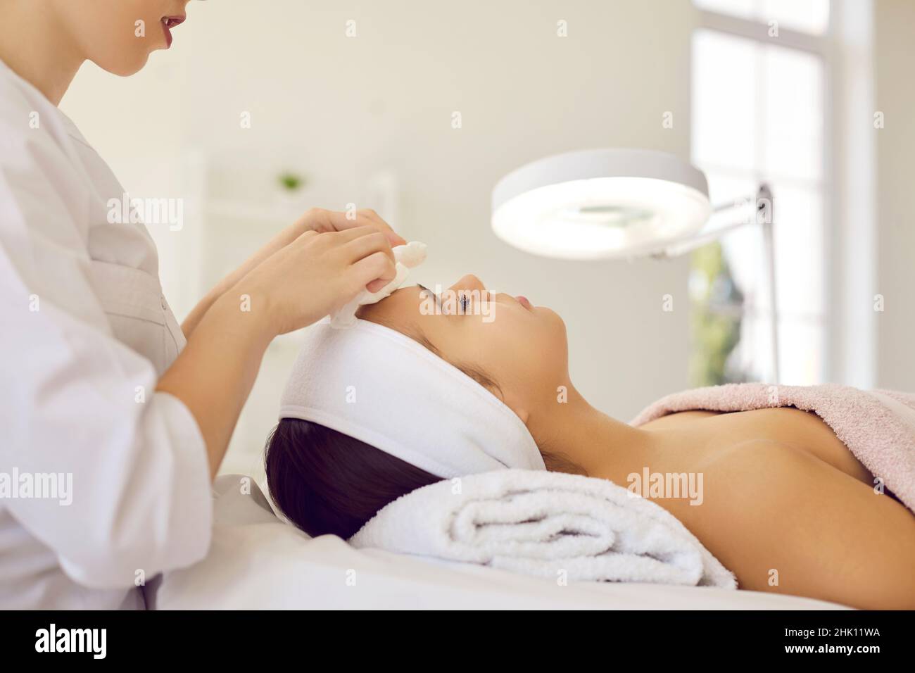 Kosmetikerin machen Gesichtsreinigungsverfahren für weibliche Klientin Stockfoto