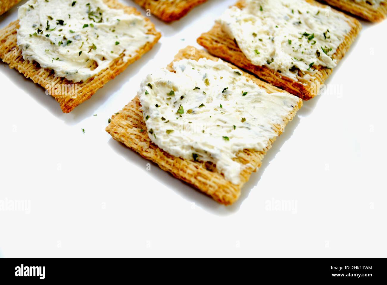 Zerfetzte Wheat Cracker mit cremigem Käse, Knoblauch und Kräutern Stockfoto