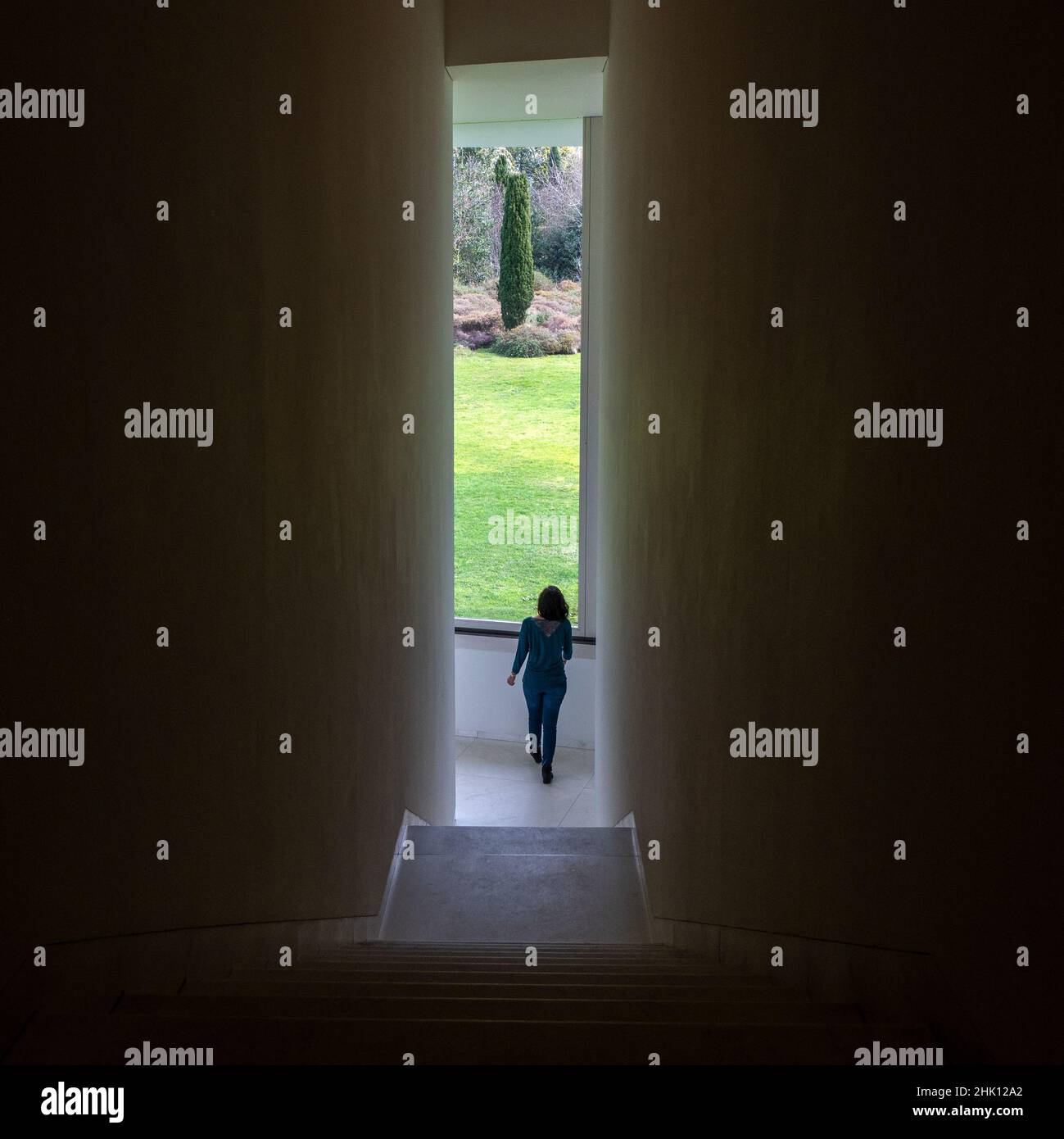 Junges Mädchen, das durch einen engen Korridor eines Museums läuft Stockfoto